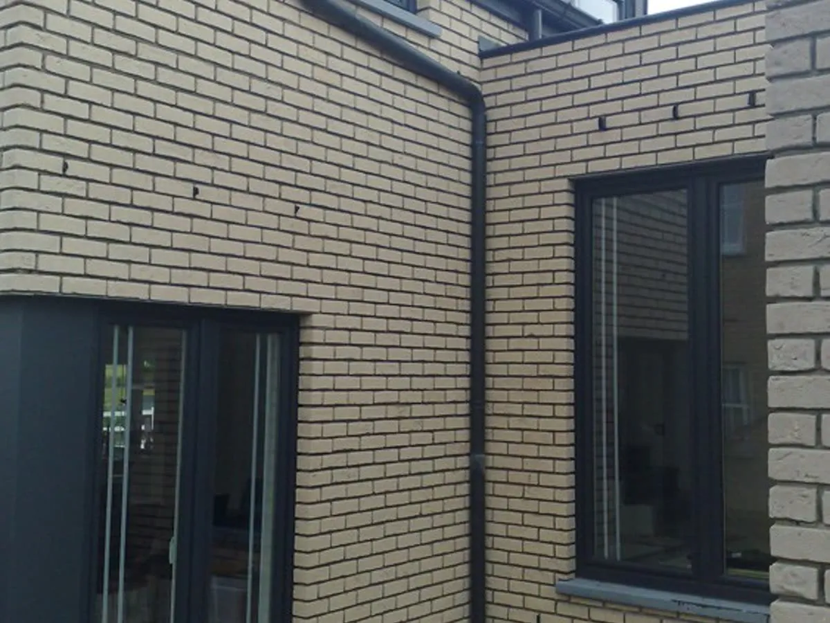 Fenster an Gebäudeecke: Zwei Öffnungen über Eck, beide in Anthrazit.